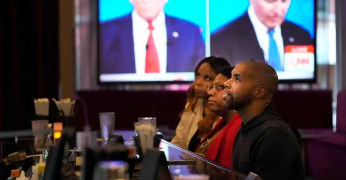 Tanzella Young, left, Crystal Blakley, center, and Jason Sanford watch the Presidential Debate at the M Lounge in the South Loop neighborhood of Chicago, Thursday. —AP Photo/Charles Rex Arbogast