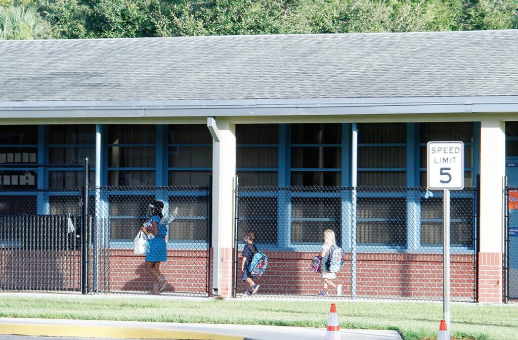 Students are escorted to Turie T. Small Elementary School in Daytona Beach on Monday morning.