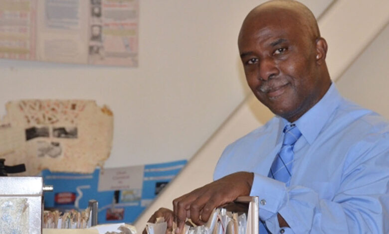 Dorsey teacher and assistant football coach Irvin Davis poses with a file cabinet filled with Black history lesson plans he has created (Amanda Scurlock/L.A. Sentinel)