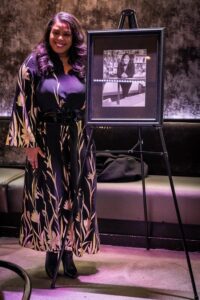 Simms poses with a portrait commissioned in her honor