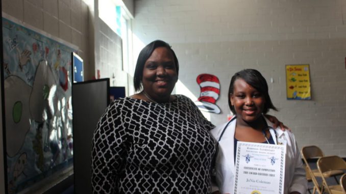 nursing_pix3-768x512 Lakecia Coleman (left) stands with her daughter Ja’Nia, 11, after receiving her certificate for completing the nursing program at Robinson Elementary School. (Ariel Worthy/The Birmingham Times)