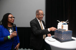 NNPA Executive Administrator Claudette Perry helps present NNPA President and CEO Dr. Benjamin F. Chavis Jr. with a birthday cake and gift/Mark Mahoney, Dream in Color