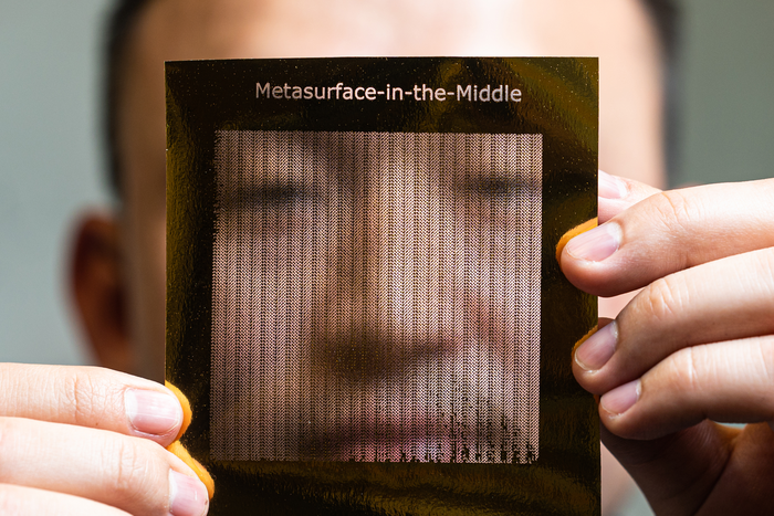 Rice University graduate student Zhambyl Shaikhanov holds a foil sheet he used to create a “metasurface” — a paper sheet covered with a 2D foil pattern — that an eavesdropper could use in a “Metasurface-in-the-Middle” attack to redirect part of a high-frequency “pencil beam” transmission like those planned for 6G wireless networks.(Jeff Fitlow/Rice University)