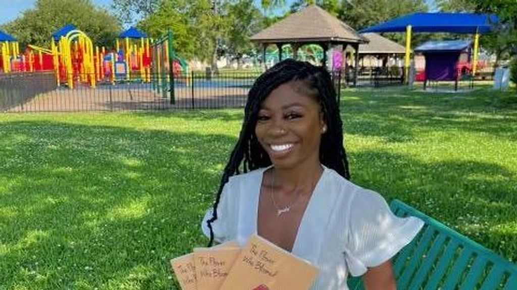 Jada White poses with her first published poetry book, “The Flower Who Bloomed.” (Jada White)