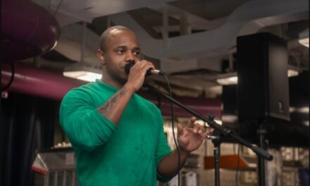 Baltimore native sings during a open mic night while serving aboard USS Ronald Reagan