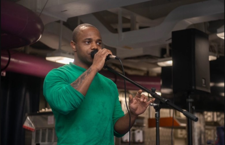 Baltimore native sings during a open mic night while serving aboard USS Ronald Reagan