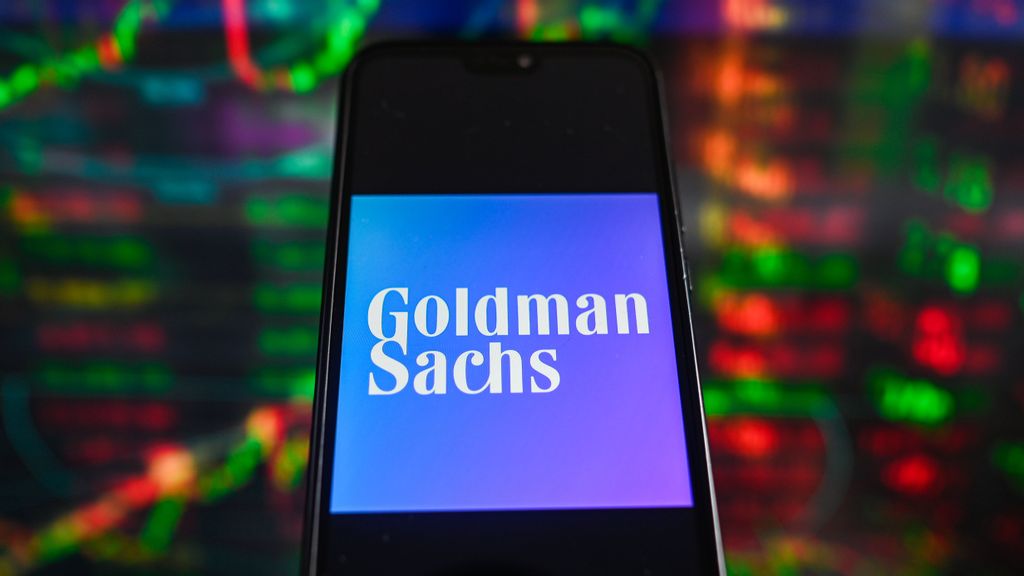 In this photo illustration a Goldman Sachs logo is displayed on a smartphone with stock market percentages in the background. PHOTO BY OMAR MARWUES/GETTY IMAGES