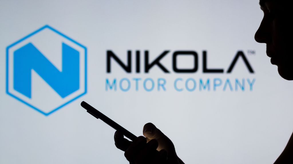  Nikola Corporation logo is seen in the background of a silhouetted woman holding a mobile phone. The amendment will change the required votes from a majority of the outstanding common stock to a majority of the shares actually voting on the proposal. RAFAEL HENRIQUE/SOPA IMAGES/LIGHTROCKET VIA GETTY IMAGES.