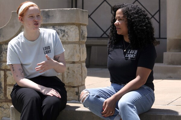 Voting rights activists Chloe Chaffin, left, and Anita Alexander talk about the work of their Kansas group, Loud Light, at Washburn University, Friday, May 18, 2024, in Topeka, Kan. Their group does voter registration drives on college campuses but has suspended that work while it challenges a state elections law that it says hampers registration drives. Laws passed in several Republican-controlled states are making it challenging for advocates to adapt as they try to register and educate potential voters with just months to go before the presidential election. (AP Photo/John Hanna)