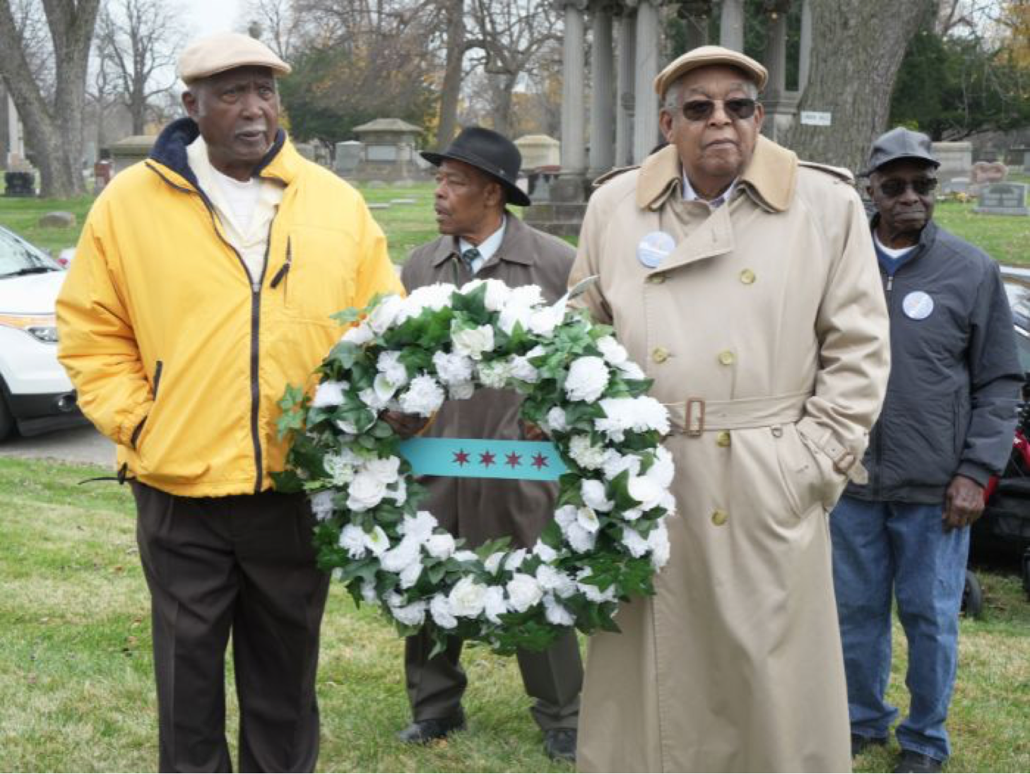 Members of Mayor Harold Washington’s police detail carry a wreath to be placed on his grave Wednesday at Oak Woods Cemetery on Monday (Photo Credit: Tacuma R. Roeback).